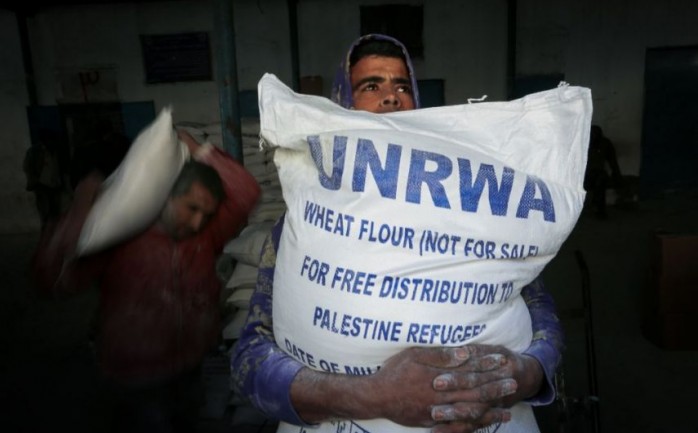 مواطن يحمل مساعدة من أونروا في غزة